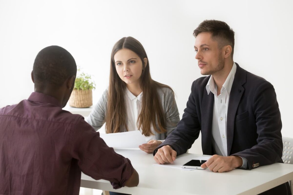 Três pessoas estão conversando durante uma entrevista de emprego.