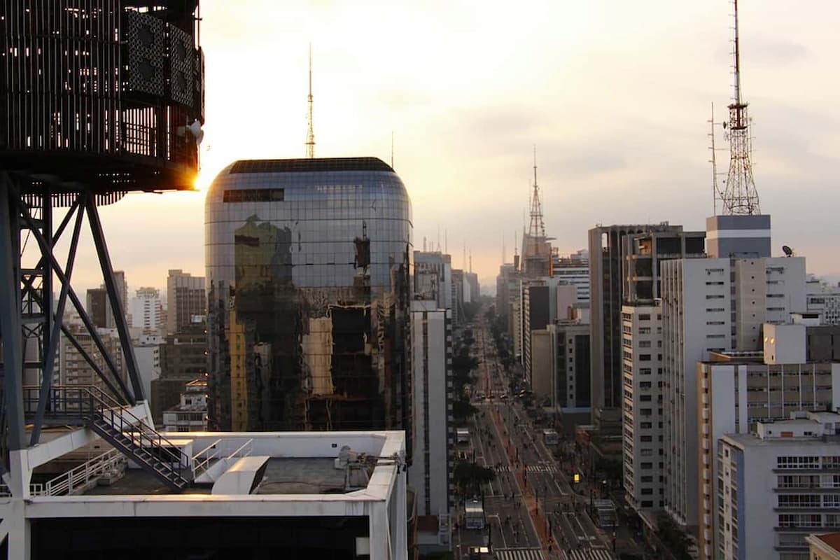 Vista aérea de paisagem urbana em São Paulo, com diversos prédio alto durante o pôr do sol.