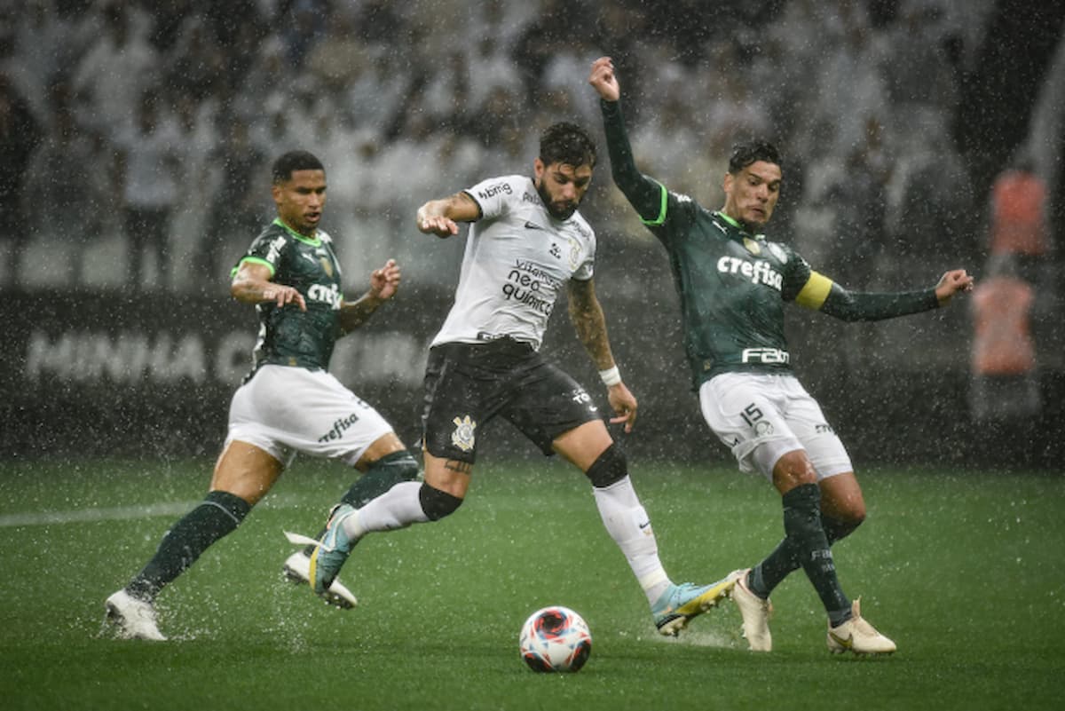 Jogadores do Corinthians e Palmeiras disputando bola durante jogo em campo.